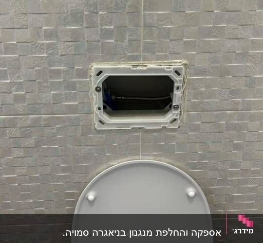 פתח בקיר עם צינור מתכת ליד אסלה